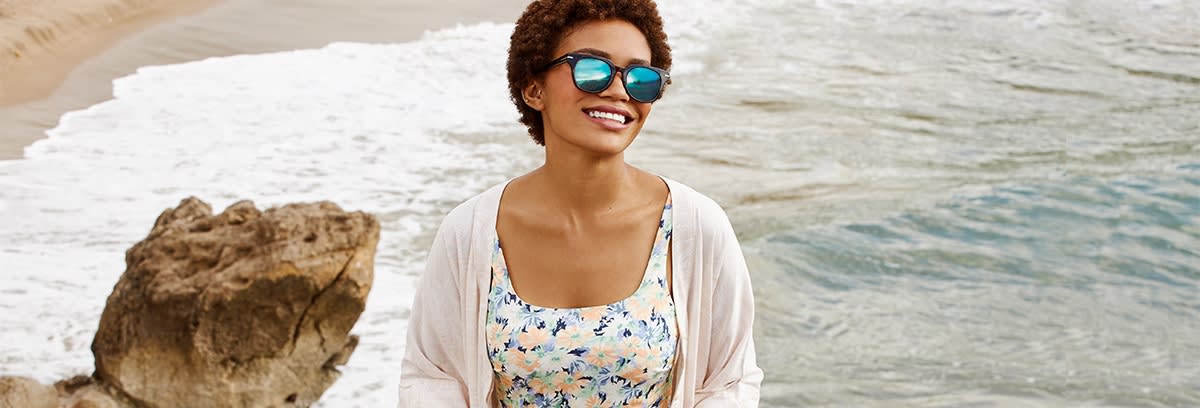 Kvinne med solbriller med speilglass på stranden.