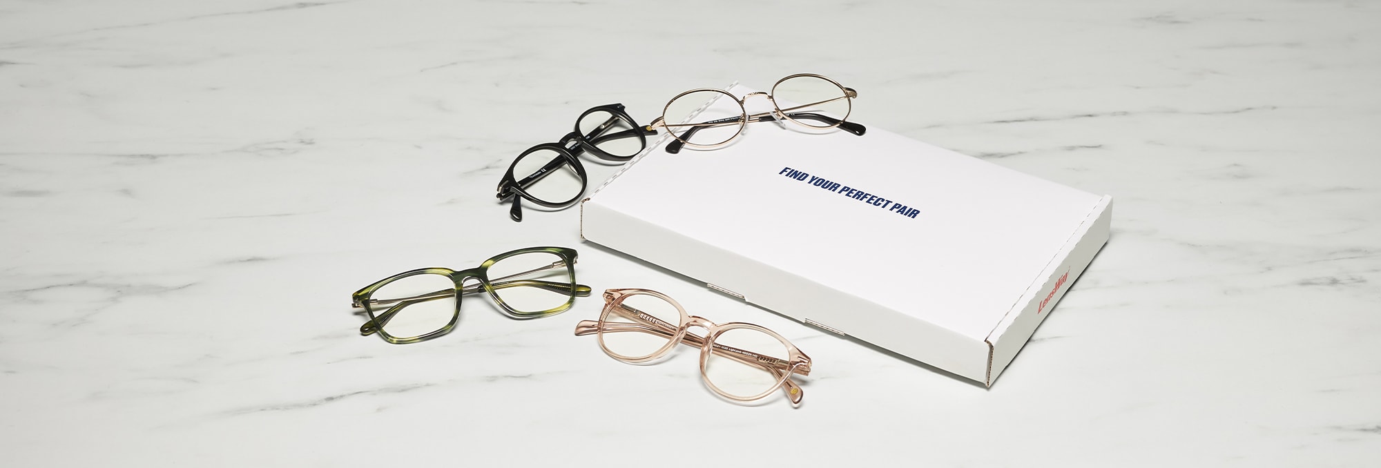 Glasögonbågar i olika former och färger med en vit låda som har texten: Find your perfect pair