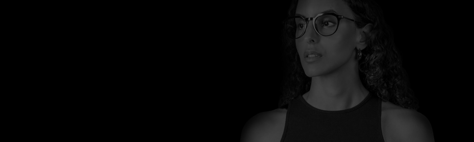Mustavalkoinen muotokuva naisesta, jolla on silmälasit ja joka katsoo vasemmalle