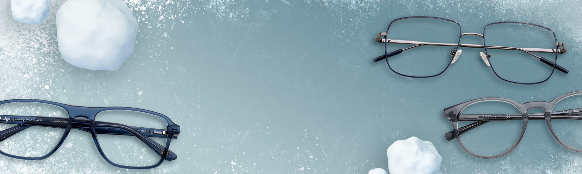 Blåa, gråa och svarta glasögon ligger på isen tillsammans med snöbollar.