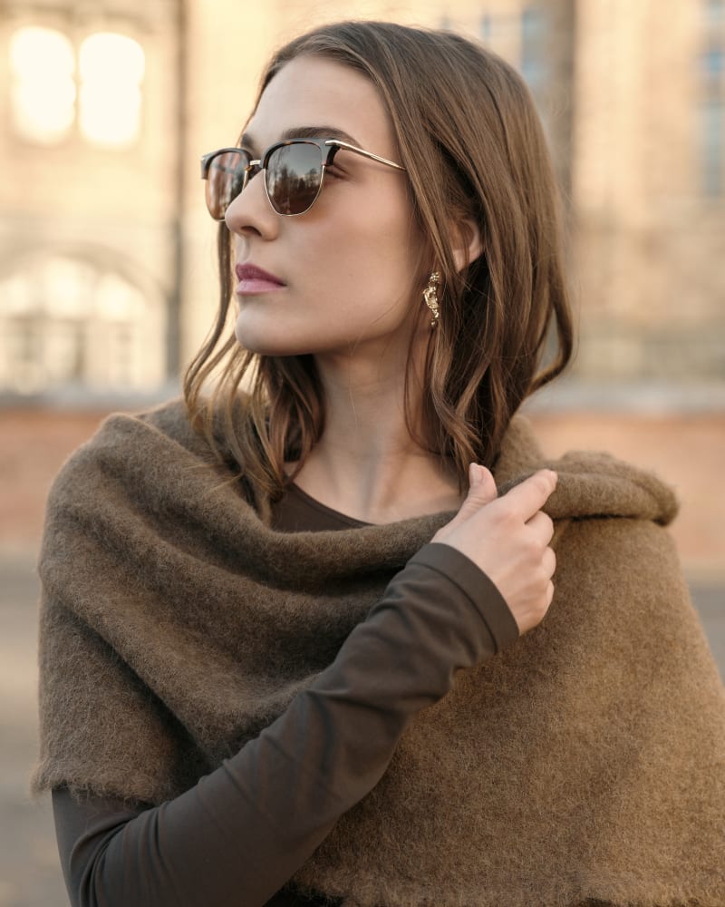 Side profile of a woman wearing Pulsar CJ2425 sunglasses. Her hair flows naturally as she tilts her head slightly, showcasing the semi-rimless design of the frame.