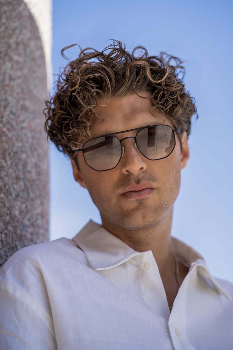 A man gazing into the camera, wearing C.Jacobsen Porla CJ2417. The sunglasses is a light weighted, sleek metal frame.