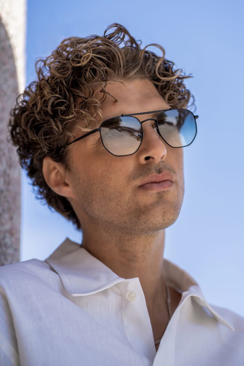 A man gazing into the camera, wearing C.Jacobsen Porla CJ2417. The sunglasses is a light weighted, sleek metal frame.