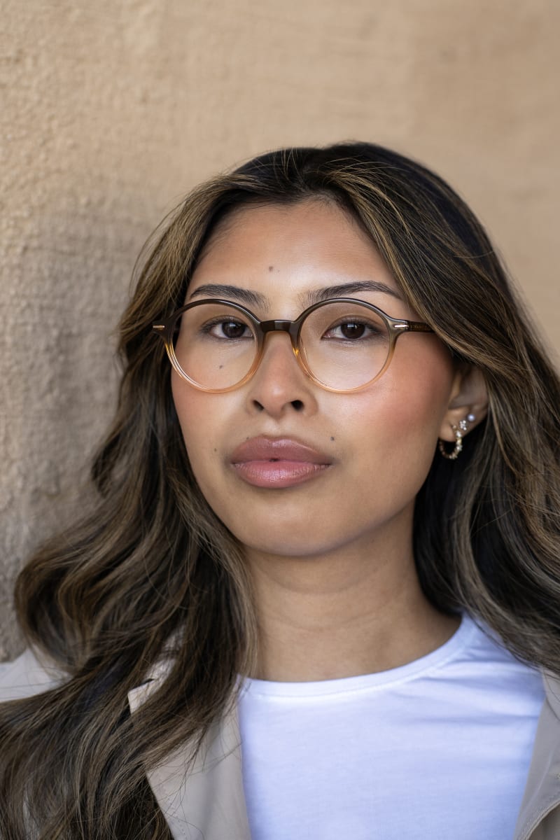 A woman is wearing C.Jacobsen Eyeglasses CJ9010. A plastic round frame in a brown and beige gradient color.