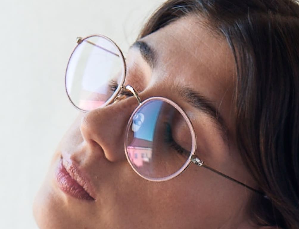 Nærbilde av kvinne med lyserosa metallbriller.